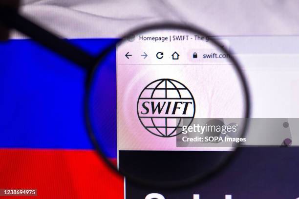 In this photo illustration, the Society for Worldwide Interbank Financial Telecommunication logo seen displayed on a computer screen through a...