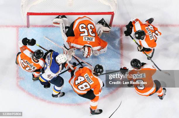 Goaltender Martin Jones of the Philadelphia Flyers tries to find the loose puck in his crease as Gerry Mayhew, Morgan Frost, Keith Yandle, and Nick...