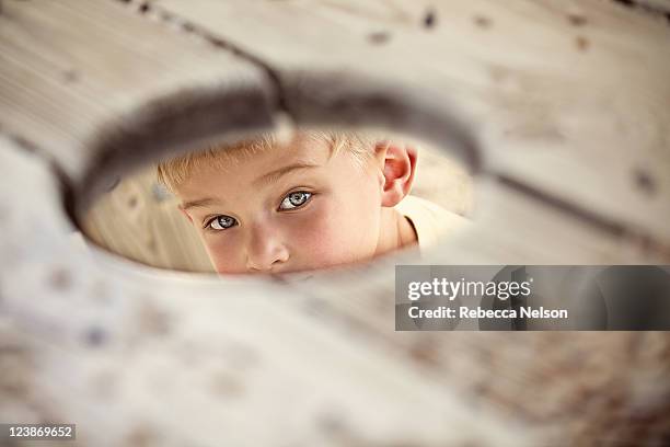 Boy Peeking Through Hole High-Res Stock Photo