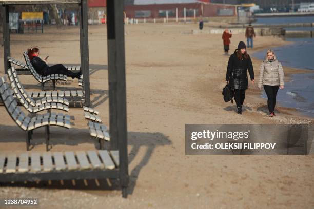 Women walk along a coast of the Sea of Azov in Ukraine's industrial port city of Mariupol on February 23, 2022. Mariupol lies on the edge of the...