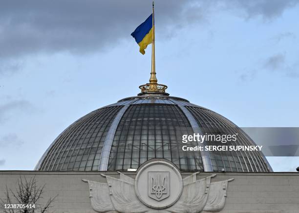 This photograph taken on February 23, 2022 shows the Ukrainian the flag fluttering above the dome of the parliament in Kyiv. - Ukraine's security...