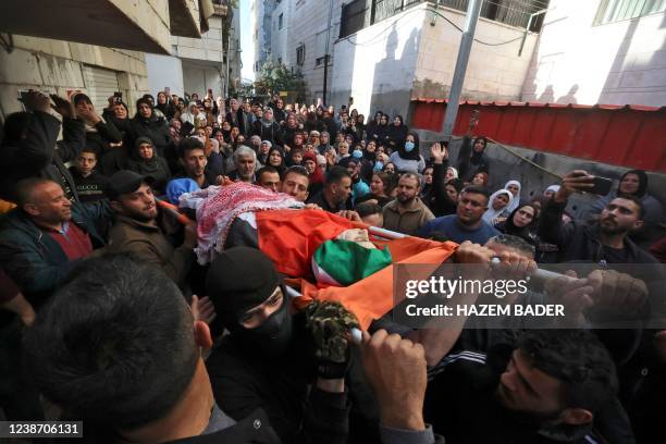 Graphic content / Palestinians cary the shrowded body of Mohammed Shehade during his funeral in al-Khader village south the occupied West Bank town...