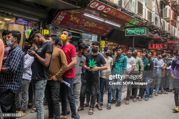 People wait in a queue to receive a dose of the Sinopharm COVID-19 vaccine , during a mass vaccination campaign in Dhaka.