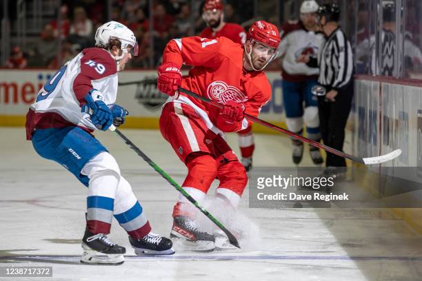 Filip Zadina of the Detroit Red Wings sumps the puck as Samuel Girard of the Colorado Avalanche pressures him along the boards during the third...