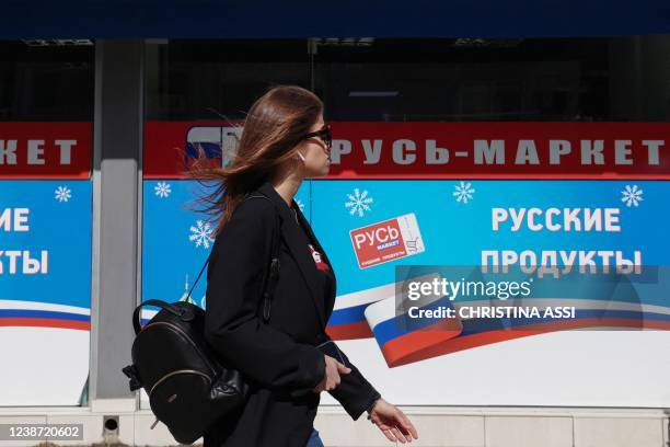 Woman walks past a Russian supermarket in the Mediterranean seaside town of Limassol in southern Cyprus, on February 23, 2022. - Ukrainians living...