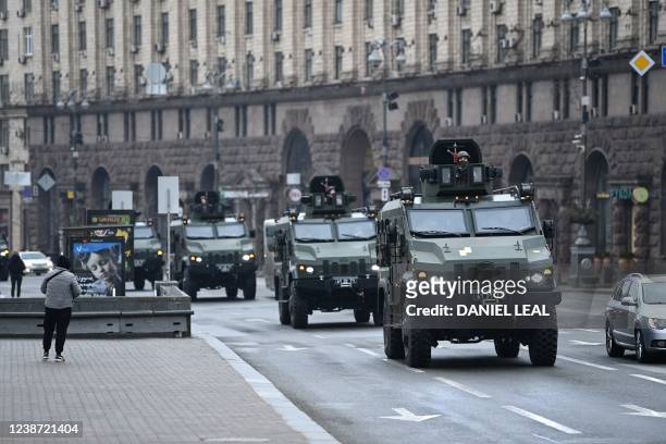 Ukrainian military vehicles move past Independence square in central Kyiv on February 24, 2022. - Air raid sirens rang out in downtown Kyiv today as...