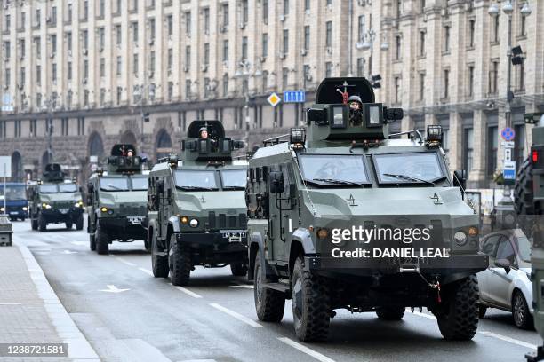 Ukrainian military vehicles move past Independence square in central Kyiv on February 24, 2022. - Air raid sirens rang out in downtown Kyiv today as...