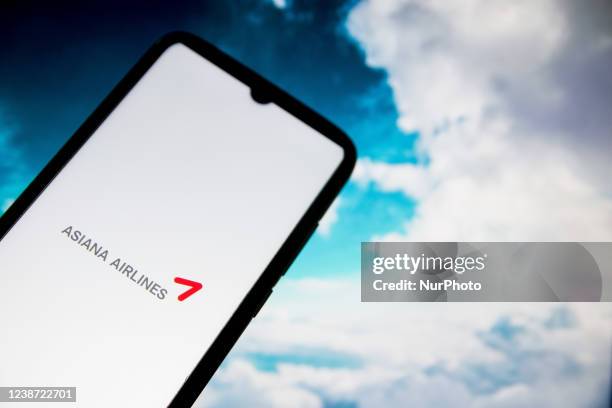 In this photo illustration an Asiana Airlines logo seen displayed on a smartphone screen with a computer wallpaper in the background in Athens,...