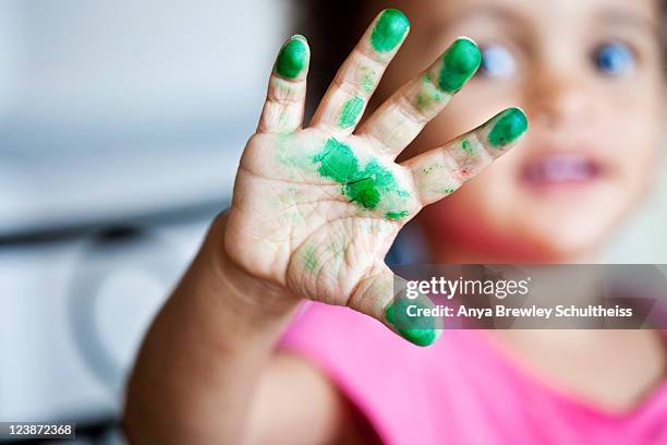 young girl showing her hand covered in green paint - baby paint hand stock-fotos und bilder
