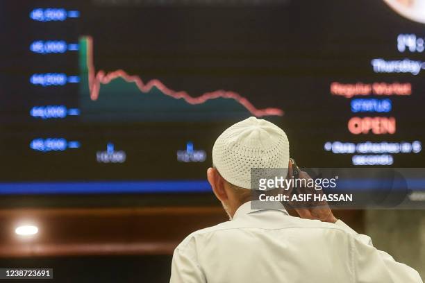 Stockbroker monitors the latest share prices during a trading session at the Pakistan Stock Exchange in Karachi on February 24, 2022.