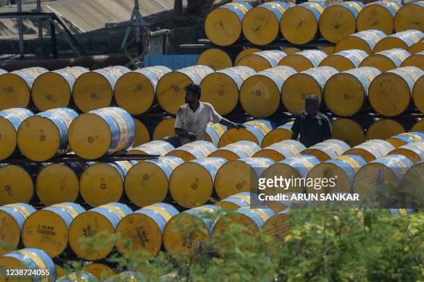 Worker stacks oil barrels at a filling station in n Chennai on February 24, 2022.