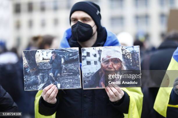 Demonstrator holding images taken in Kharkiv and published by Anadolu Agency during a protest held near Brandenburg gate against Russia's full-scale...