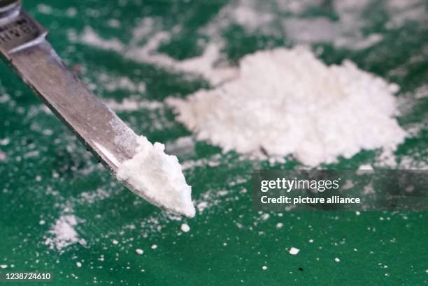 February 2022, Hamburg: A press officer of the Hamburg Customs presents a small part of the seized cocaine at a media event in the port. Customs...