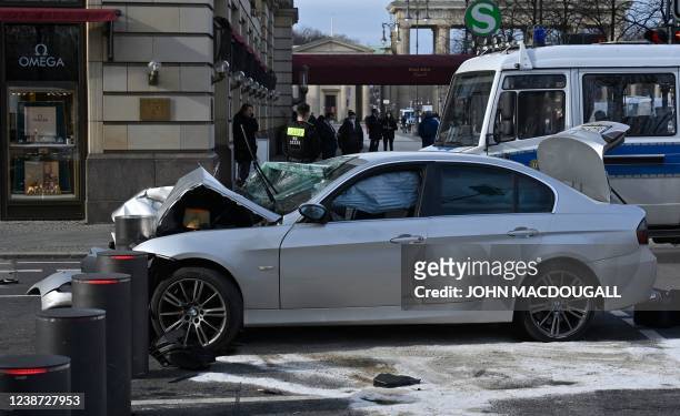 Police secure the scene after a car crashed into a security fence blocking off traffic in front of the British embassy and close to the Brandenburg...