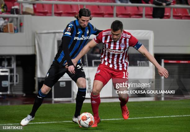 Olympiacos' defender Sokratis Papastathopoulos fights for the ball with Atalanta's defender Hans Hateboer during the UEFA Europa League second leg...