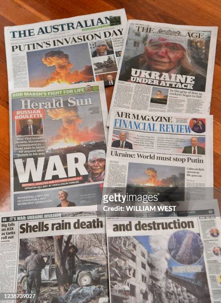 This photo illustration taken in Melbourne on February 25, 2022 shows front pages of newspapers reporting on the Russian invasion of Ukraine.