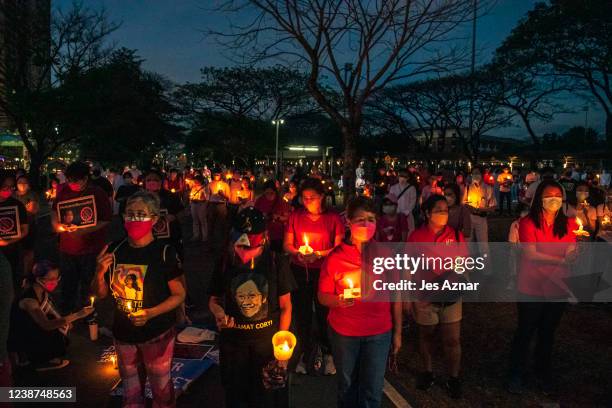 Filipinos light candles and offer prayers as they commemorate the 36th anniversary of People Power that ousted dictator Ferdinand Marcos, on February...