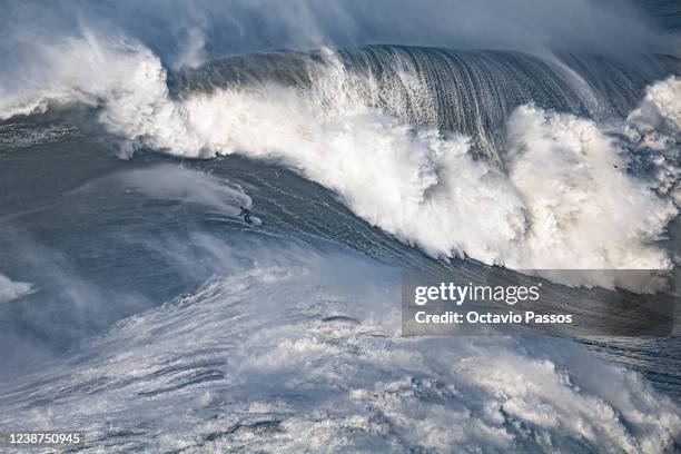 Big wave surfer Lucas Fink from Brazil rides a wave during a surfing session at Praia do Norte on February 25, 2022 in Nazare, Portugal.