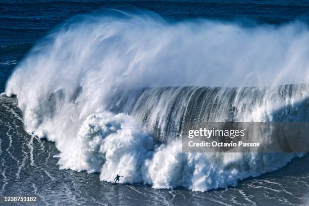 Big wave surfer rides a wave during a surfing session at Praia do Norte on February 25, 2022 in Nazare, Portugal.