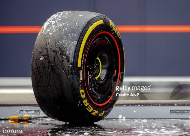 Red Bull Racing mechanic cleans Pirelli's new 18-inch Formula 1 tire in the paddock during the third and final day of testing at Spain's Circuit de...