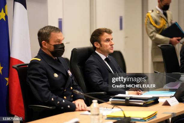 French President Emmanuel Macron watches a huge screen during a video-conference with NATO members at the French Army headquarters in Paris on...