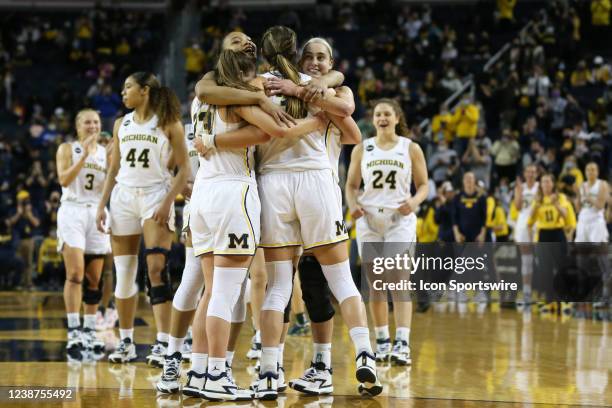 Michigan Wolverines seniors forward Naz Hillmon , left, and guard Amy Dilk , right, embrace guard Danielle Rauch and forward Emily Kiser as their...