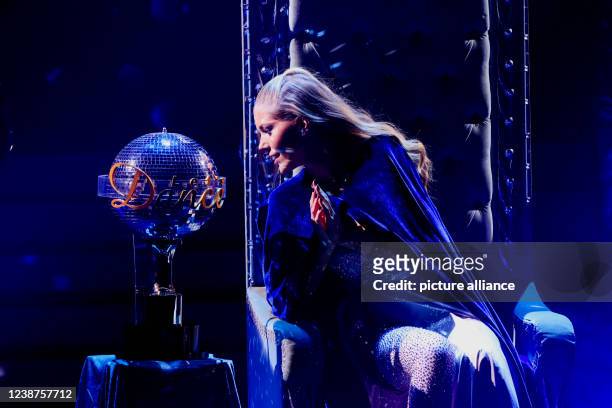 February 2022, North Rhine-Westphalia, Cologne: Victoria Swarovski, presenter, looks at the winner's trophy in the RTL dance show "Let's Dance" at...