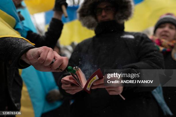 Man burns his Russian passport as members of the Ukrainian community protest in front of the Consulate General of the Russian Federation on February...