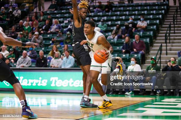 Clyde Trapp of the Charlotte 49ers attempts to get past Seth Pinkney of the Florida International Golden Panthers during a basketball game between...