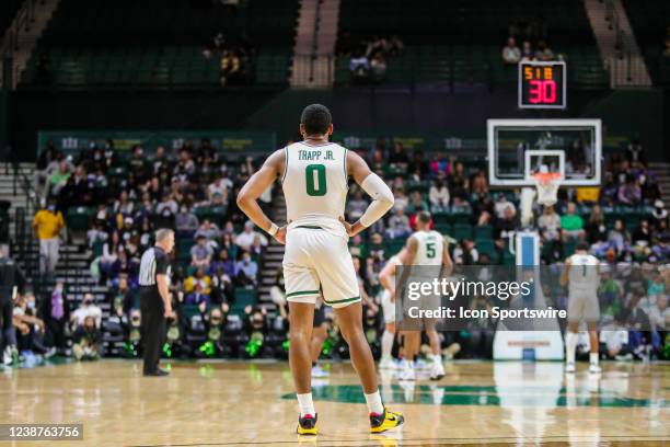 Clyde Trapp of the Charlotte 49ers looks on as Jahmir Young of the Charlotte 49ers shoots free throws at the opposite end of the court during a...