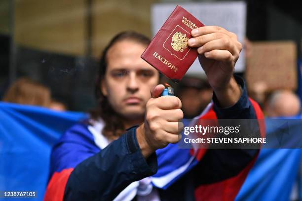 Russian man burns his passport during a protest against Russia's invasion of Ukraine, in Sydney on February 26, 2022.