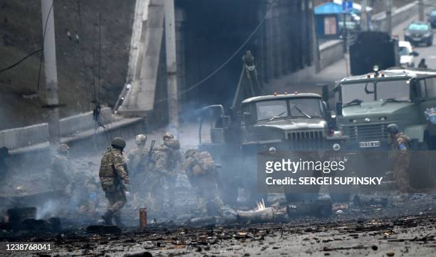 Ukrainian service members collect unexploded shells after a fighting with Russian raiding group in the Ukrainian capital of Kyiv in the morning of...