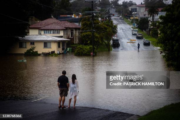 Residents look at rising floodwaters of the Bremer river in West Ipswich, Australia's Queensland state on February 26, 2022.