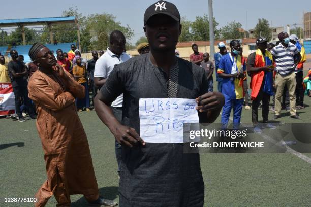 Man displays a paper reading "Either URSS or nothing" during a demonstration in N'Djamena on February 26, 2022 called by the opposition platform...