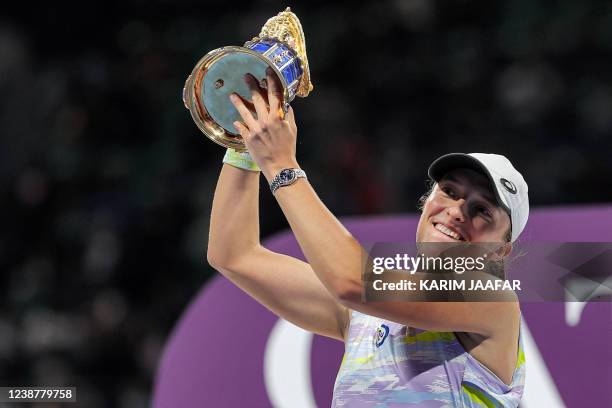 Iga Swiatek of Poland lifts up the winner's trophy after winning the final match of the 2022 WTA Qatar Open in Doha on February 26, 2022.