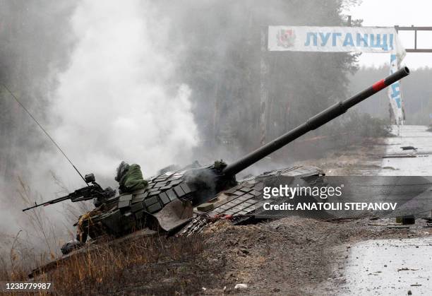 Smoke rises from a Russian tank destroyed by the Ukrainian forces on the side of a road in Lugansk region on February 26, 2022. - Russia on February...