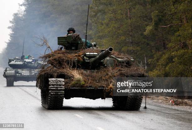 Ukrainian tanks move on a road before an attack in Lugansk region on February 26, 2022. - Russia on February 26 ordered its troops to advance in...