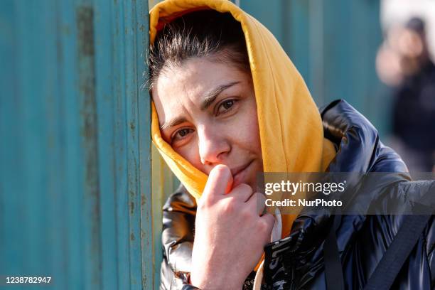 Ukrainian woman waits by the border crossing passage for an arrival of her loved ones as tens of thousands escapees from Ukraine enter Poland after...