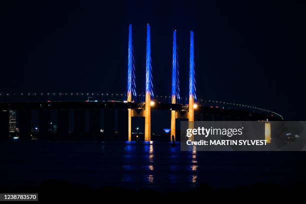 The 200-meter-high pylons on the Oresund Bridge, between Denmark and Sweden, light up in yellow and blue, in support of Ukraine, seen from...