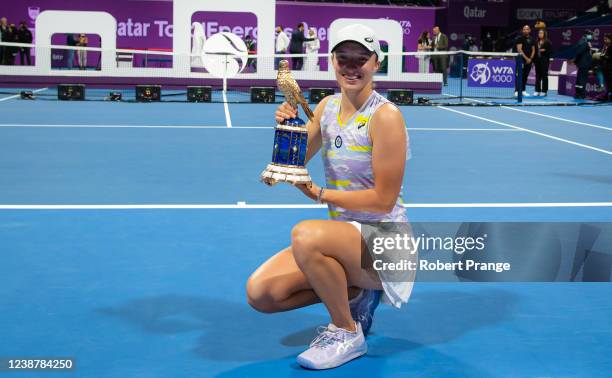 Iga Swiatek of Poland poses with the champions trophy after defeating Anett Kontaveit of Estonia in the final of the Qatar TotalEnergies Open at the...