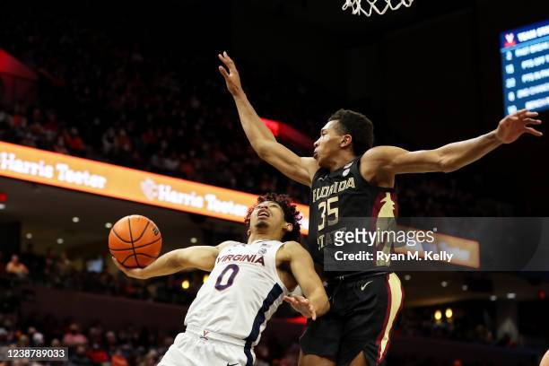 Matthew Cleveland of the Florida State Seminoles blocks a shot by Kihei Clark of the Virginia Cavaliers in the second half during a game at John Paul...