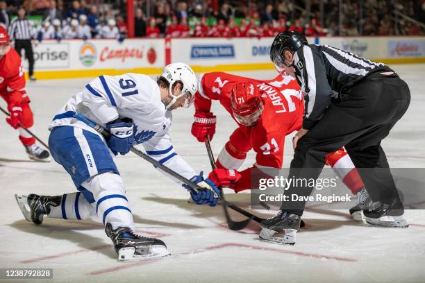 John Tavares of the Toronto Maple Leafs and Dylan Larkin of the Detroit Red Wings take a face-off during the third period of an NHL game at Little...