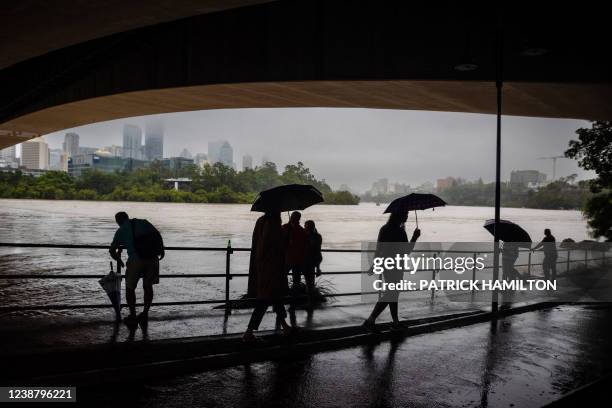 People shelter under the Captain Cook Bridge across the overflowing Brisbane River at South Bank, Australia's Queensland state on February 27, 2022.