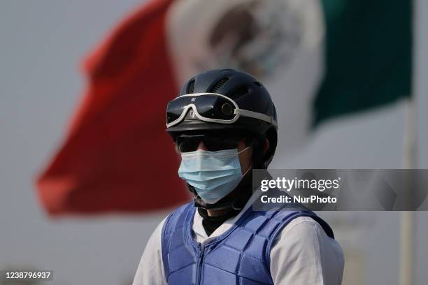 Jockey in front of a monumental flag at the Hipódromo de Las Américas in Mexico City, where some exhibitions were held, such as floreo de reata, el...