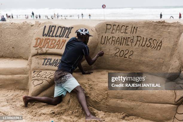 South African sand sculptor Sithembiso Buthelezi gives the final touches showing a message calling for peace between Ukraine and Russia on the North...