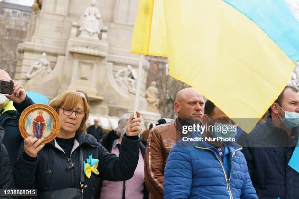 Demonstrators gather and wave flags during a protest against Russia's invasion of Ukraine in Madrid on February 27, 2022. - EU foreign ministers will...