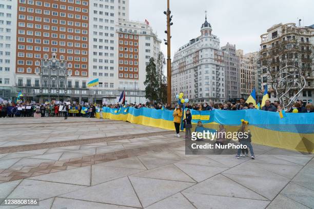 Demonstrators gather and wave flags during a protest against Russia's invasion of Ukraine in Madrid on February 27, 2022. - EU foreign ministers will...