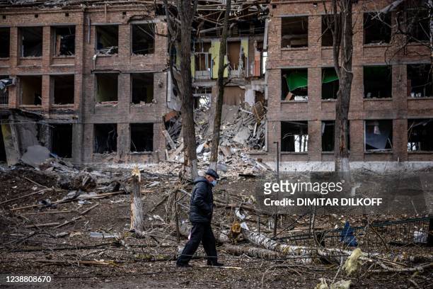 Man walks in front of a destroyed building after a Russian missile attack in the town of Vasylkiv, near Kyiv, on February 27, 2022. - Ukraine's...