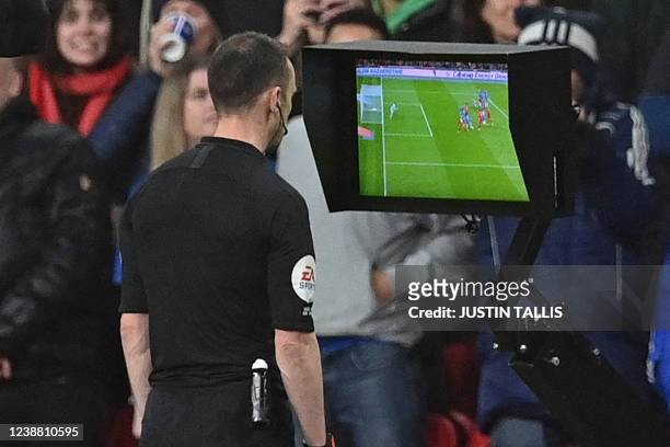 English referee Stuart Attwell checks the pitch-side monitor after being advised of a foul by the VAR , before disallowing a goal from Liverpool's...
