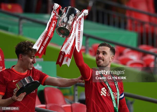 Liverpool's English midfielder Jordan Henderson holds aloft the winner's trophy after the English League Cup final football match between Chelsea and...